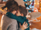 Single mom and son hugging in front of Christmas tree